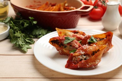 Photo of Delicious conchiglie pasta with ricotta cheese, tomato sauce and parsley on wooden table, closeup