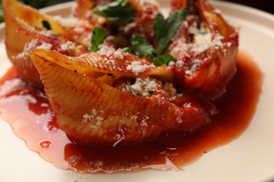 Photo of Delicious conchiglie pasta with ricotta cheese and tomato sauce on plate, closeup