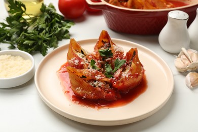 Photo of Delicious conchiglie pasta with ricotta cheese, tomato sauce and parsley on white table, closeup