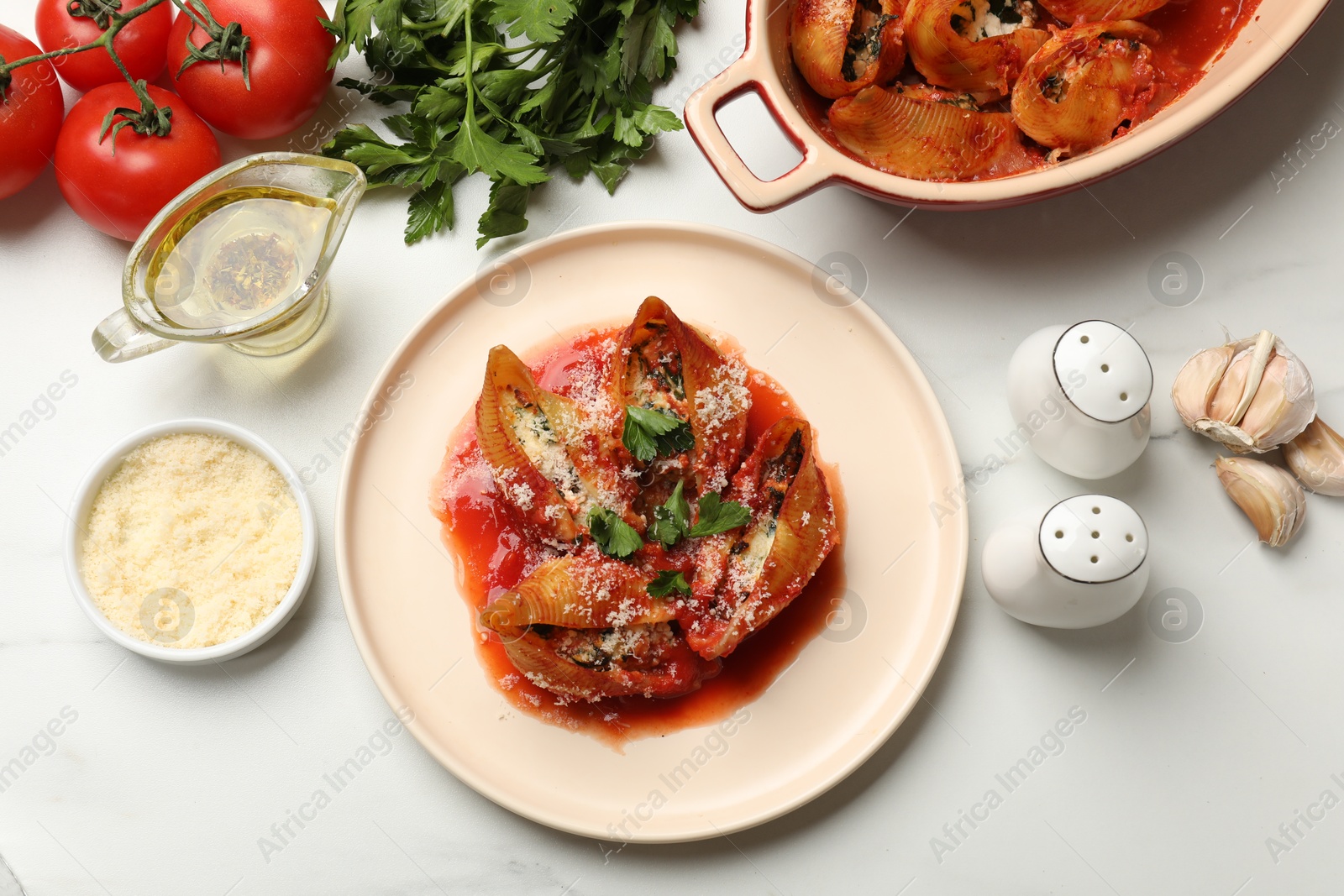 Photo of Delicious conchiglie pasta with ricotta cheese, tomato sauce and parsley on white table, flat lay