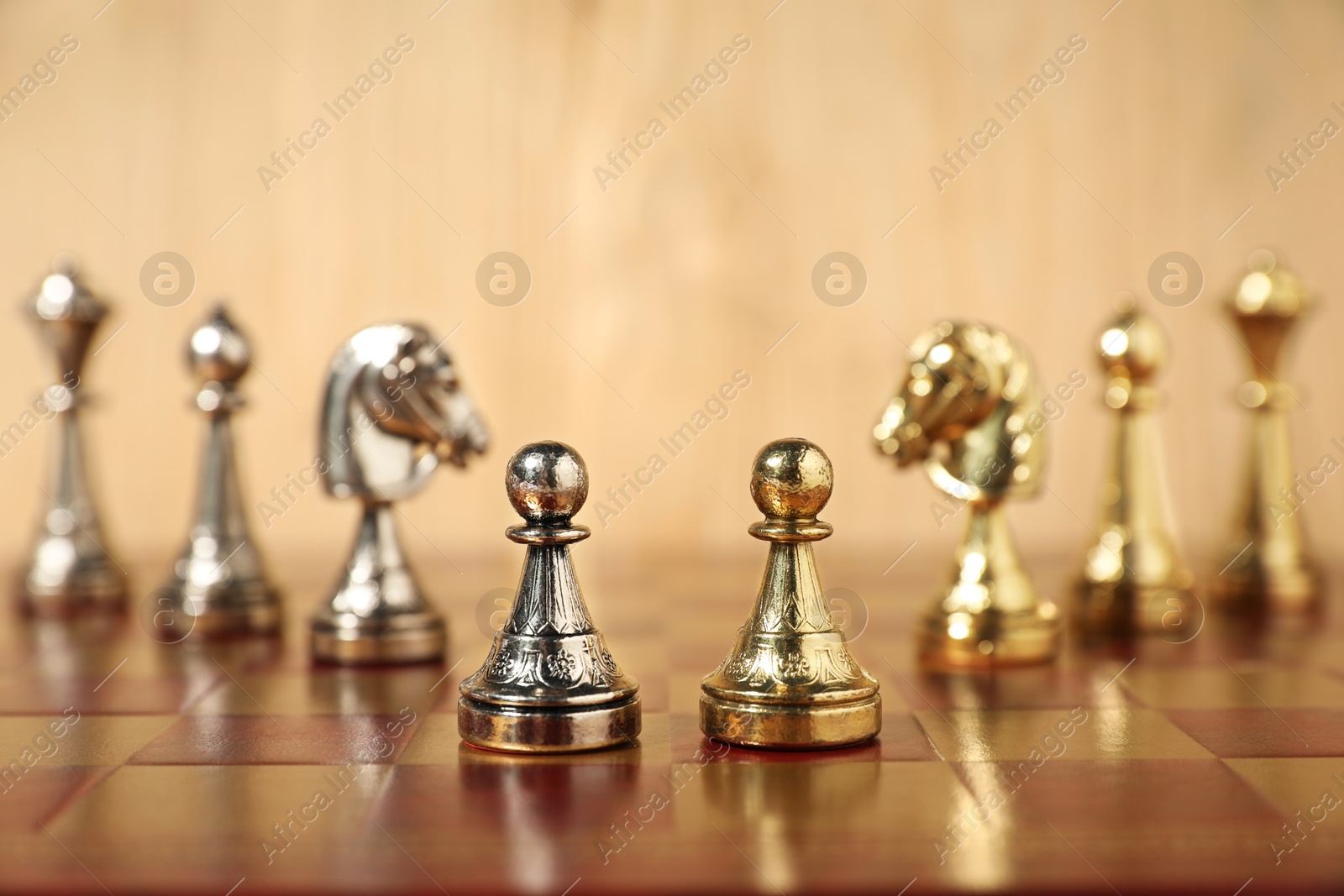 Photo of Golden and silver chess pieces on chessboard, closeup. Competition concept