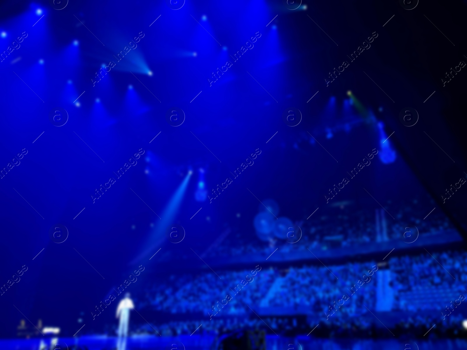 Photo of Singer performing on stage in front of audience indoors