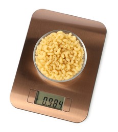 Photo of Electronic kitchen scale with bowl of raw pasta isolated on white, top view