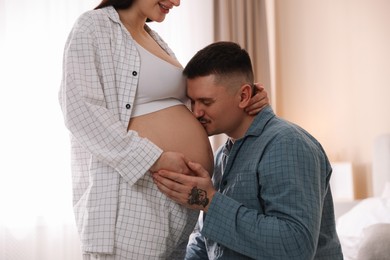 Pregnant woman and her husband at home, closeup