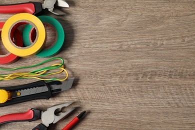 Photo of Different electrical tools on wooden table, flat lay. Space for text