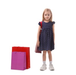 Photo of Little girl with shopping bags on white background