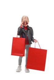 Little girl with shopping bags on white background