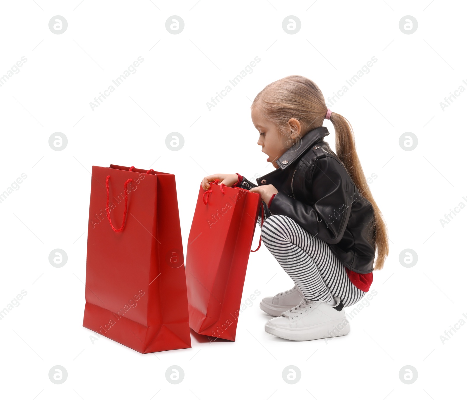 Photo of Little girl with shopping bags on white background