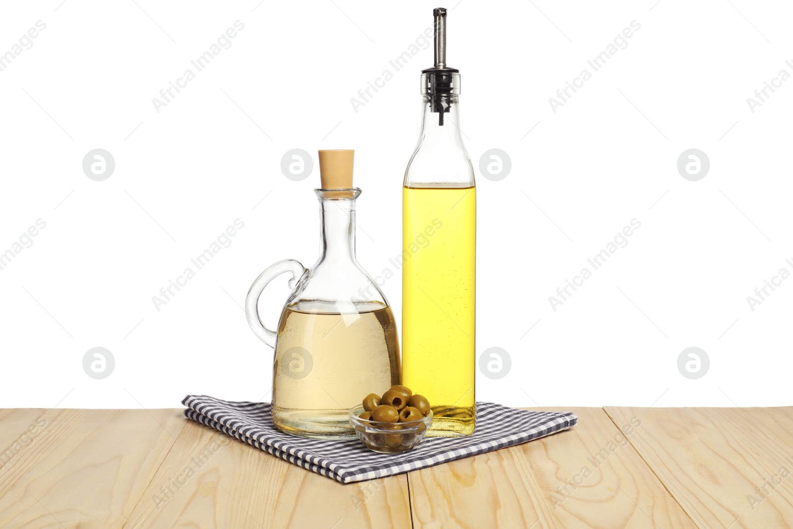 Photo of Salad dressings and olives on wooden table against white background