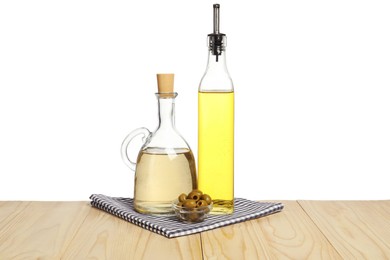 Photo of Salad dressings and olives on wooden table against white background