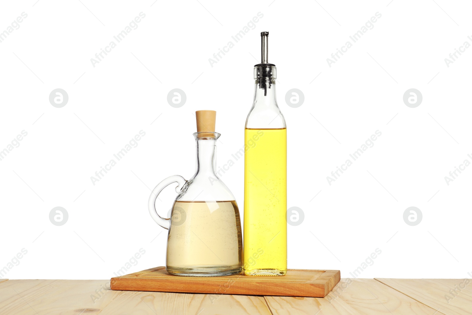 Photo of Oil and vinegar in bottles on wooden table against white background