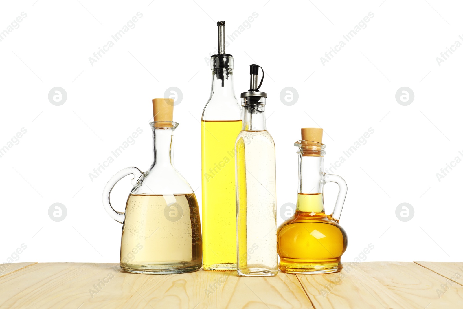 Photo of Salad dressings on wooden table against white background