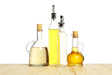 Photo of Salad dressings on wooden table against white background