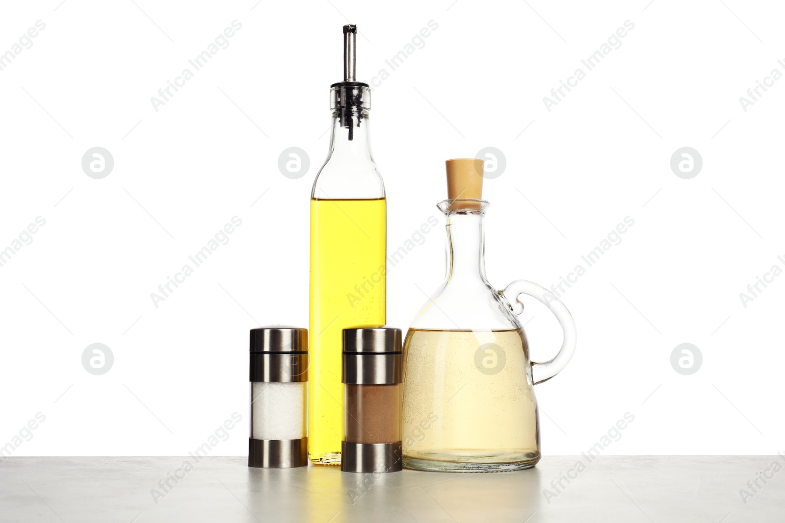 Photo of Salad dressings and spices on table against white background