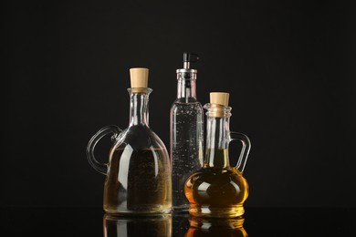 Photo of Salad dressings on mirror surface against black background