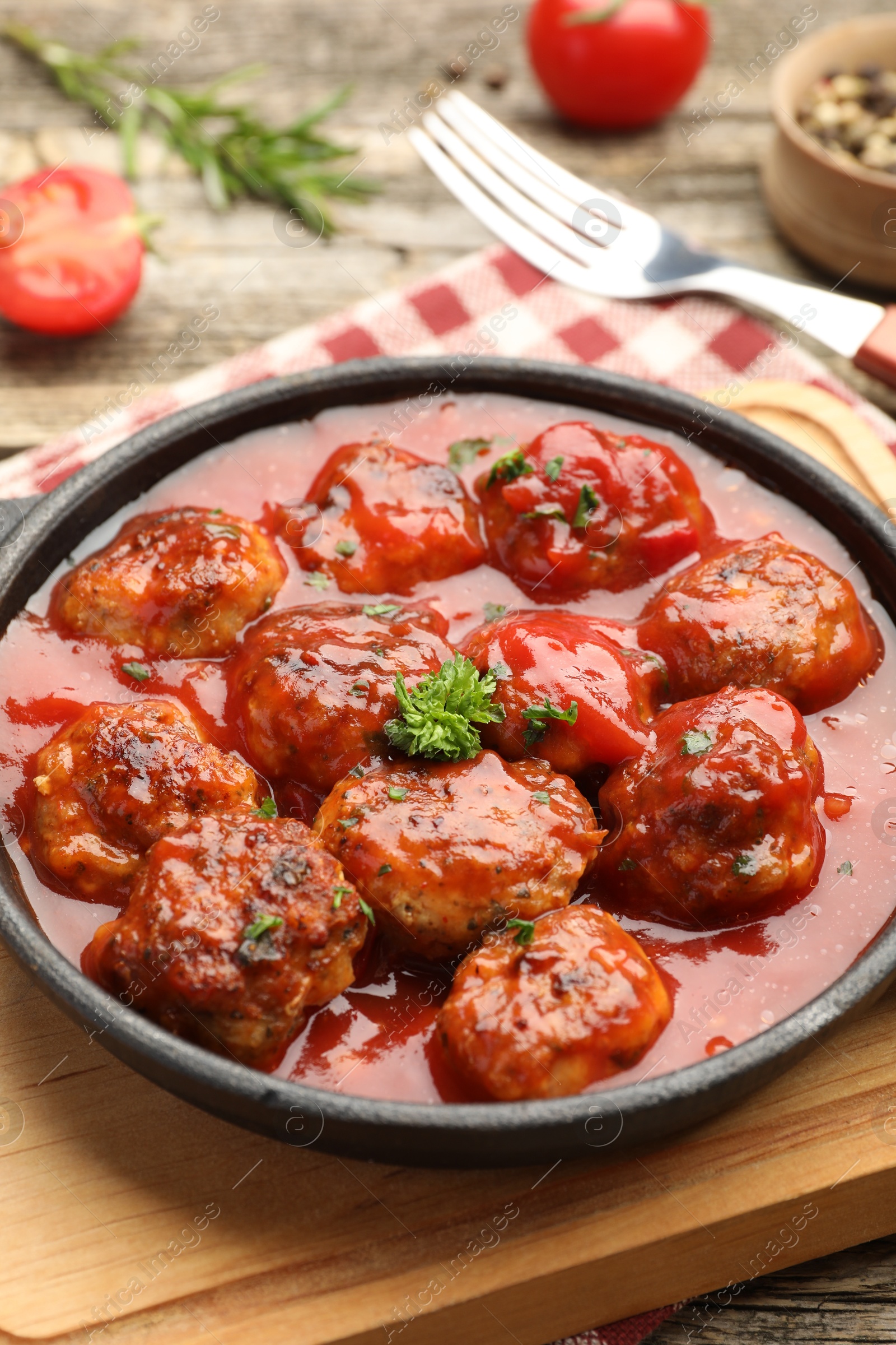 Photo of Delicious meatballs with tomato sauce in baking dish on table, closeup