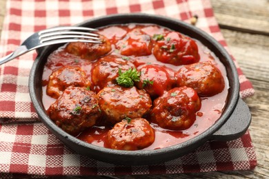 Photo of Delicious meatballs with tomato sauce in baking dish on table, closeup