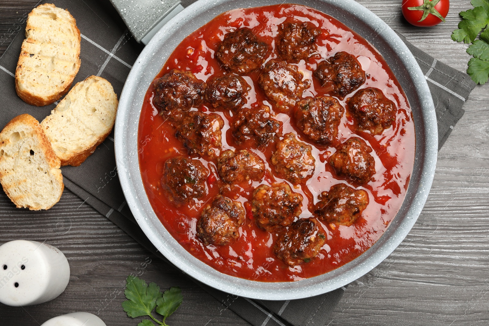 Photo of Delicious meatballs with tomato sauce served on wooden table, flat lay