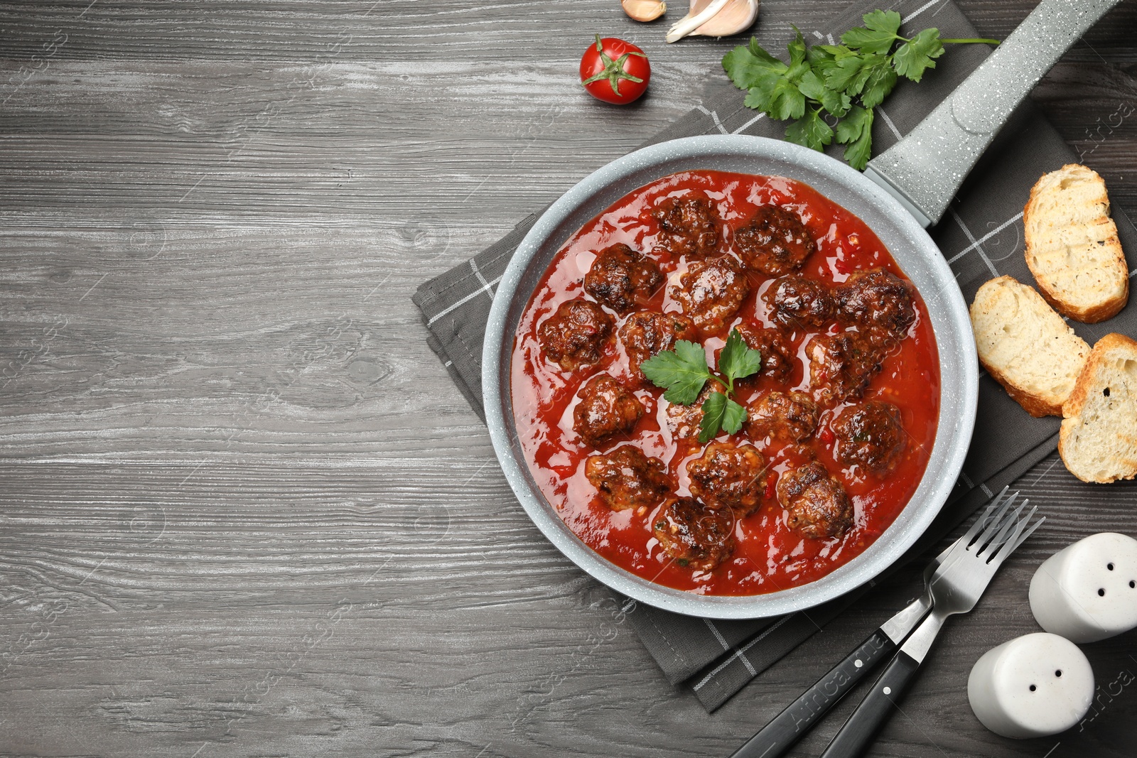 Photo of Delicious meatballs with tomato sauce served on wooden table, flat lay. Space for text