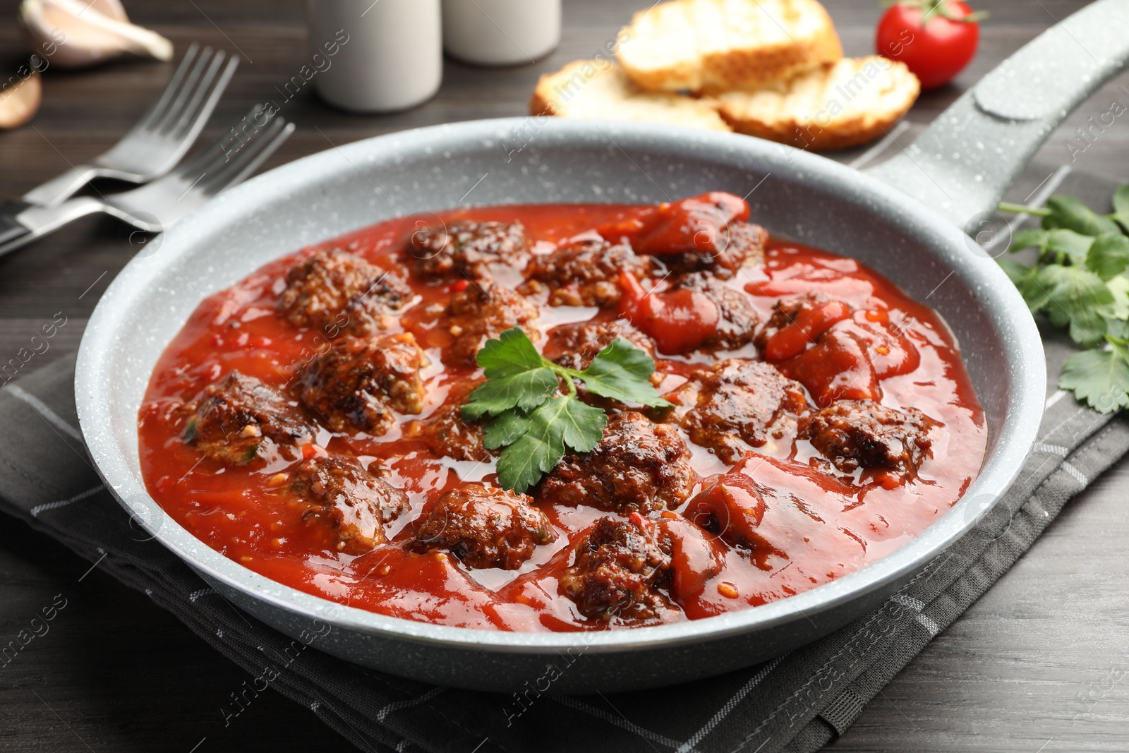 Photo of Delicious meatballs with tomato sauce served on wooden table, closeup