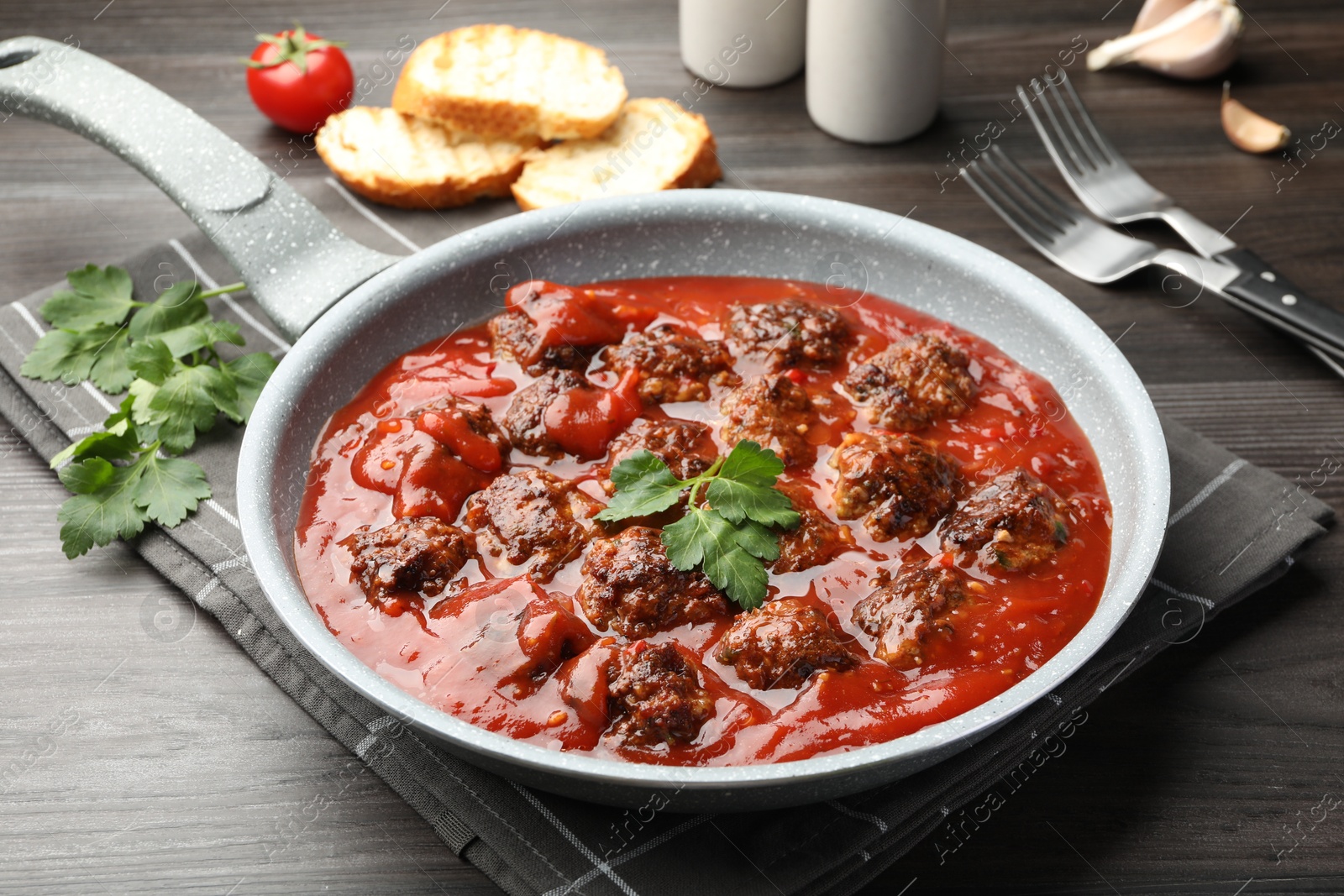 Photo of Delicious meatballs with tomato sauce served on wooden table, closeup