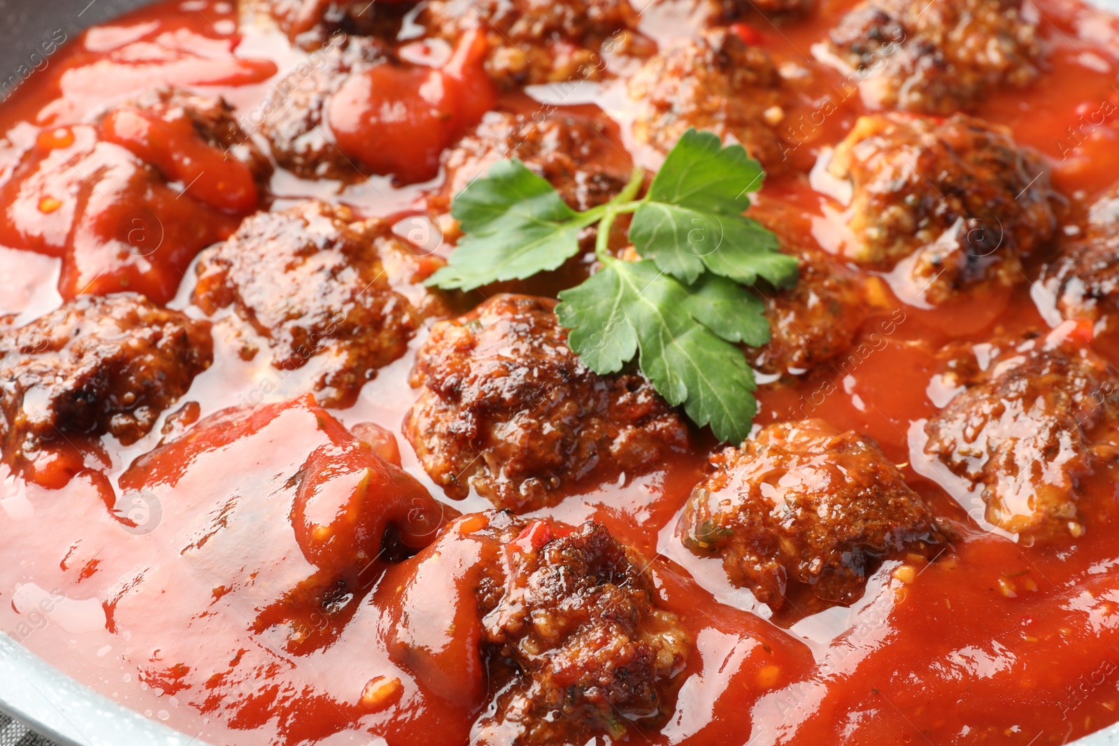 Photo of Delicious meatballs with tomato sauce and parsley in bowl, closeup