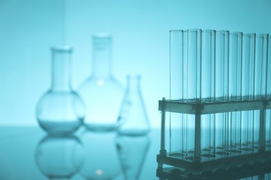 Photo of Empty test tubes on light blue background, closeup. Space for text