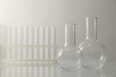 Photo of Empty flasks and test tubes on light background. Laboratory equipment