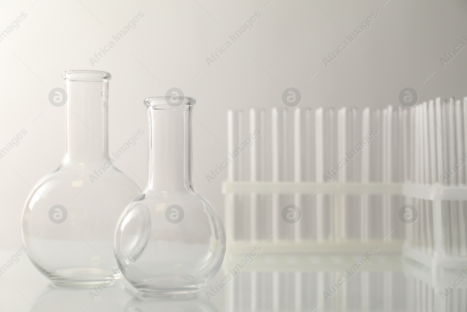 Photo of Empty flasks and test tubes on light background. Laboratory equipment