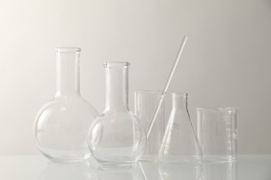 Photo of Many different laboratory glassware on light background