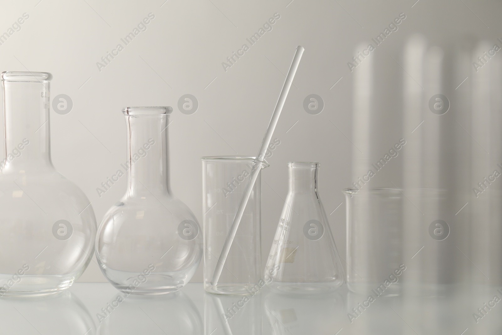 Photo of Many different laboratory glassware on light background