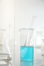 Photo of Laboratory glassware on mirror surface against light background