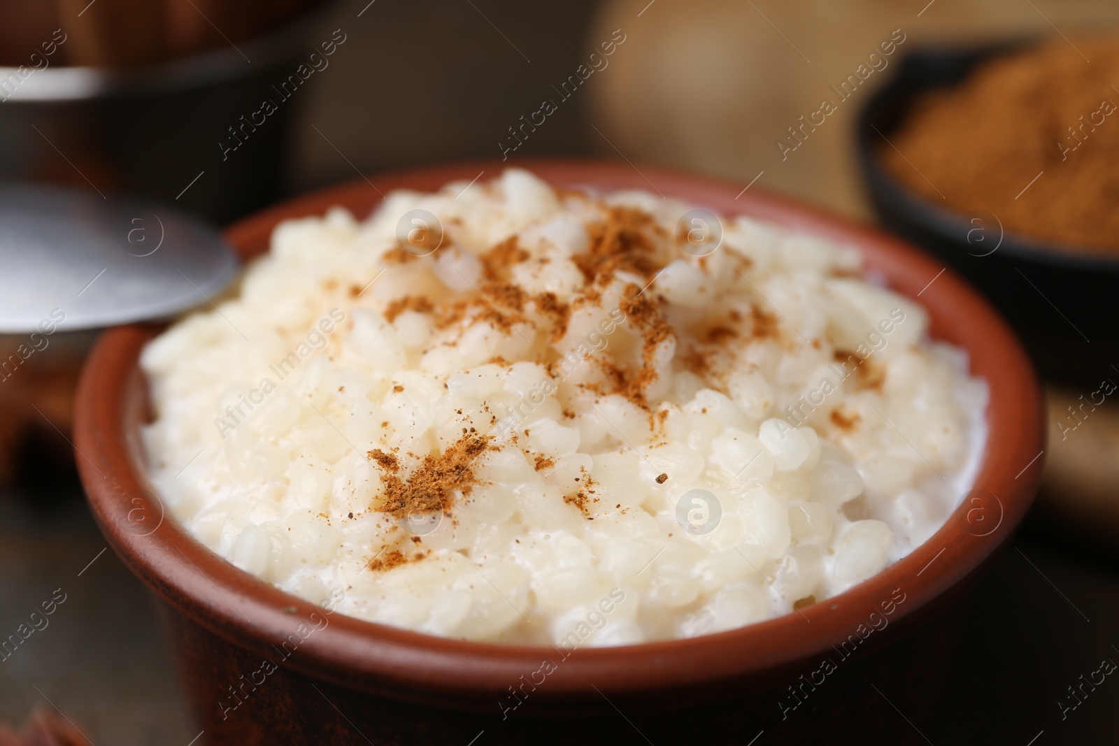 Photo of Tasty rice pudding with cinnamon on table, closeup