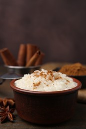 Photo of Tasty rice pudding with cinnamon served on wooden table, closeup. Space for text