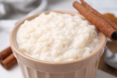 Photo of Tasty rice pudding with cinnamon on table, closeup