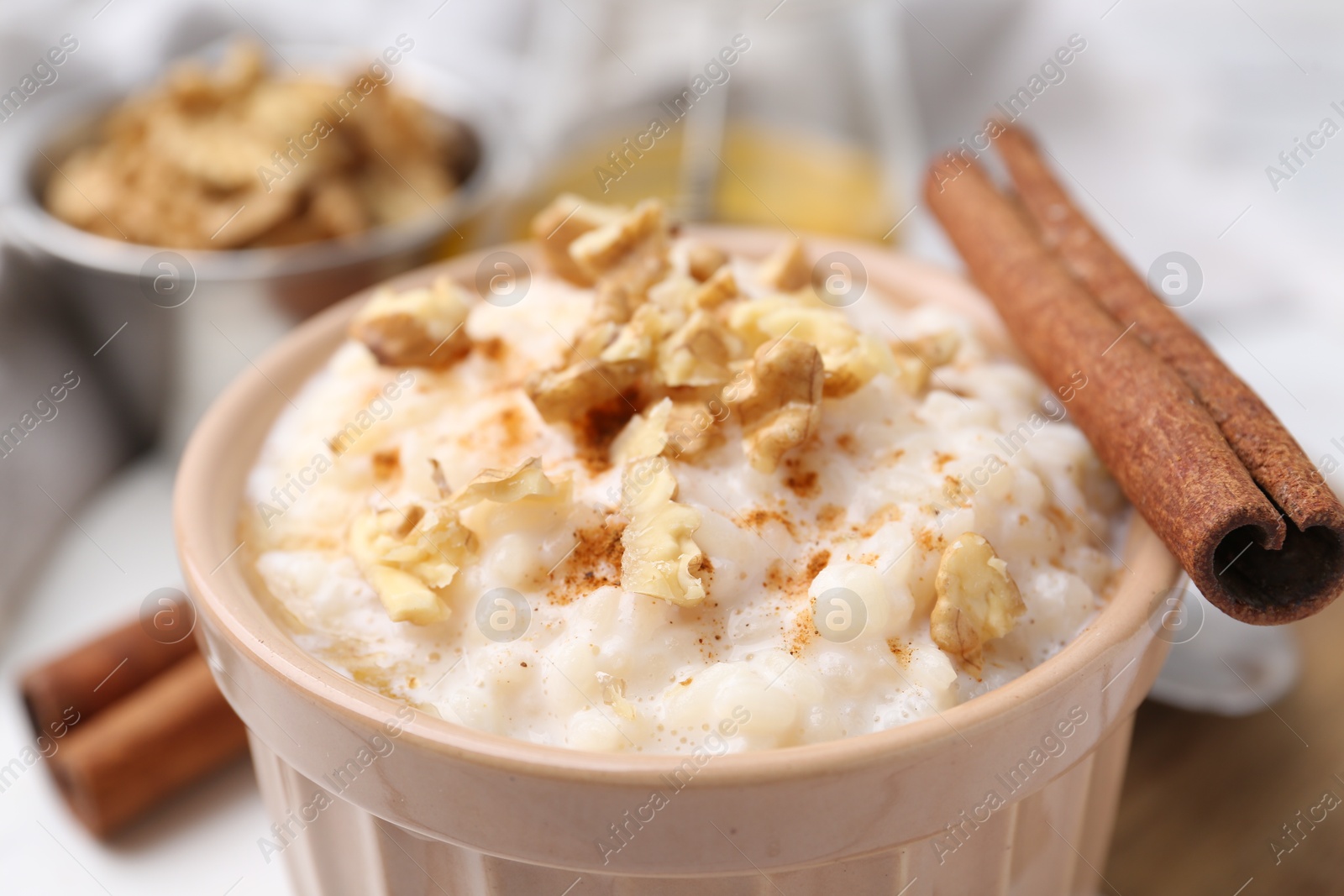 Photo of Tasty rice pudding with cinnamon on table, closeup