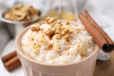 Photo of Tasty rice pudding with cinnamon on table, closeup