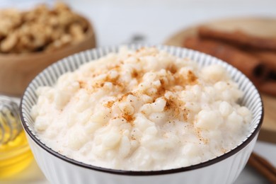 Photo of Tasty rice pudding with cinnamon on table, closeup