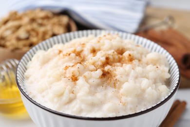 Photo of Tasty rice pudding with cinnamon on table, closeup