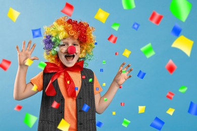 Image of Happy boy dressed like clown under falling confetti on light blue background. Party time