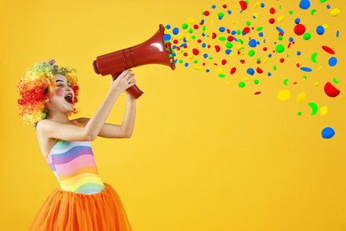 Image of Cute girl dressed like clown shouting in megaphone with confetti flying out of it on orange background. Party time