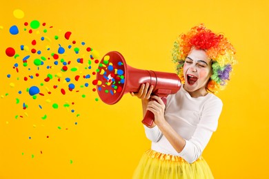 Image of Cute girl dressed like clown shouting in megaphone with confetti flying out of it on orange background. Party time