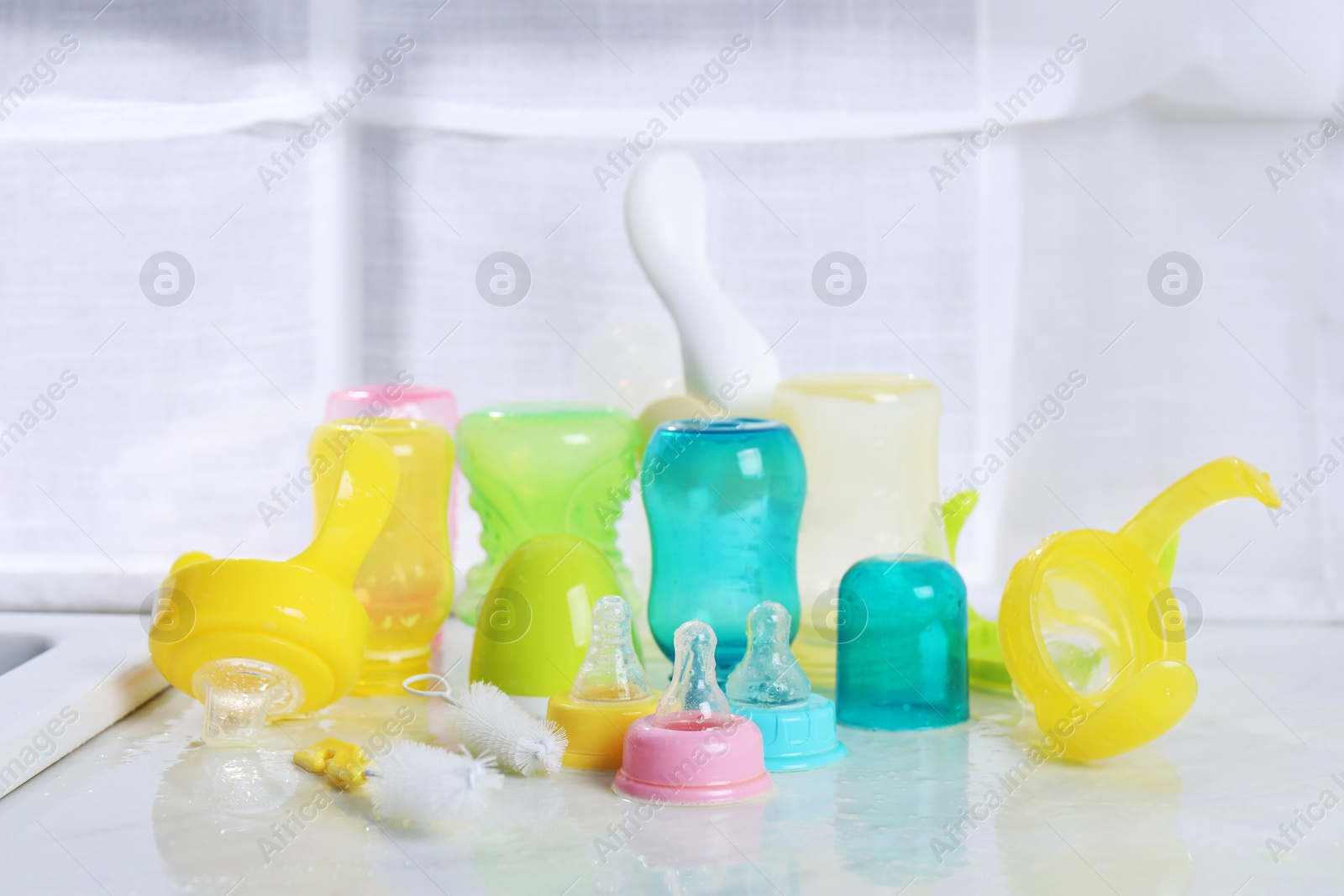 Photo of Clean feeding bottles drying on counter indoors