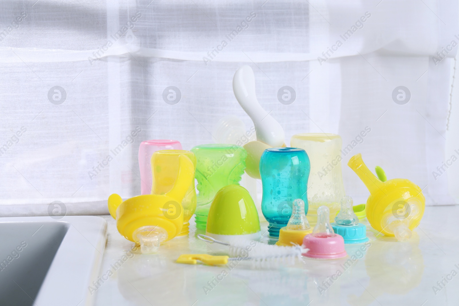 Photo of Clean feeding bottles drying on counter indoors