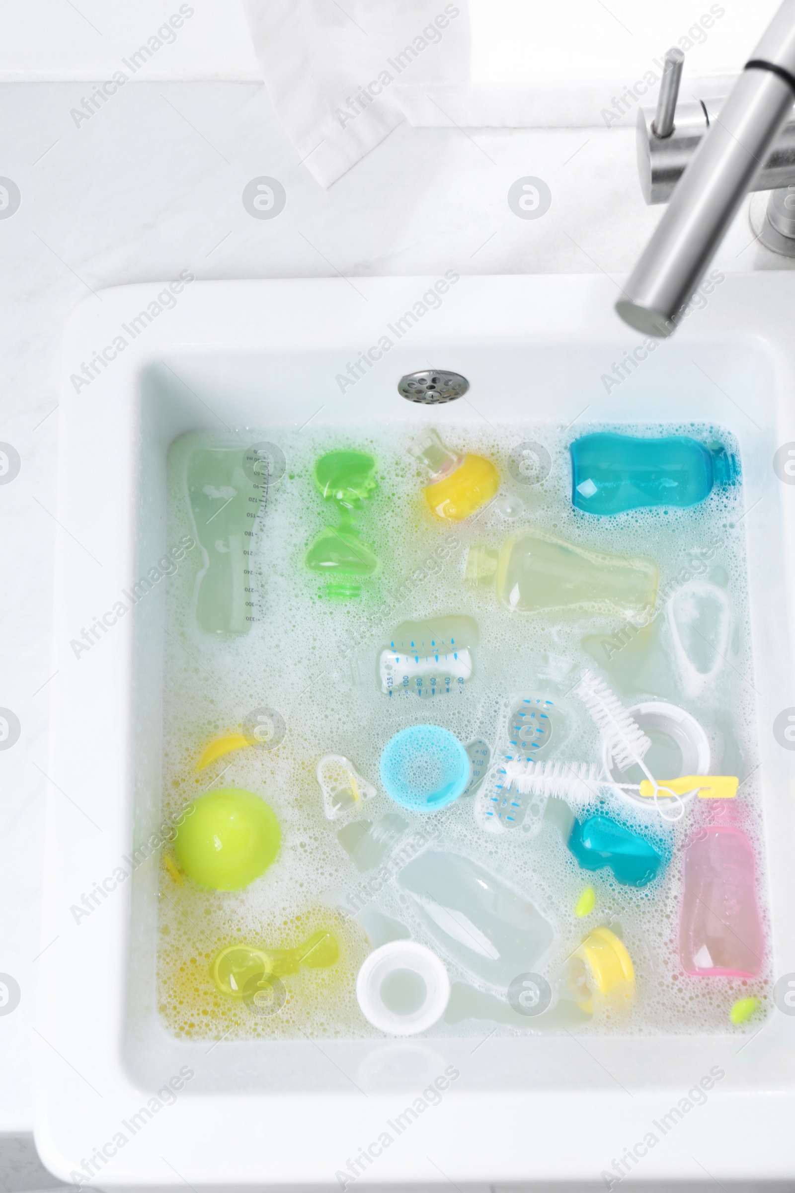 Photo of Washing feeding bottles in sink, top view