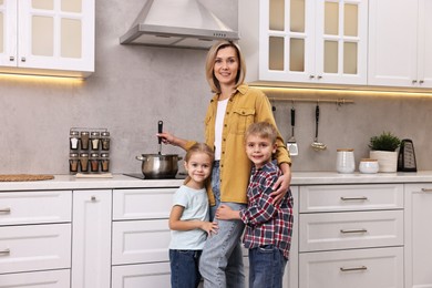 Happy housewife and her kids in kitchen