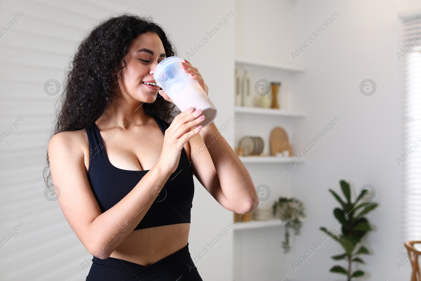 Photo of Beautiful woman drinking protein shake at home