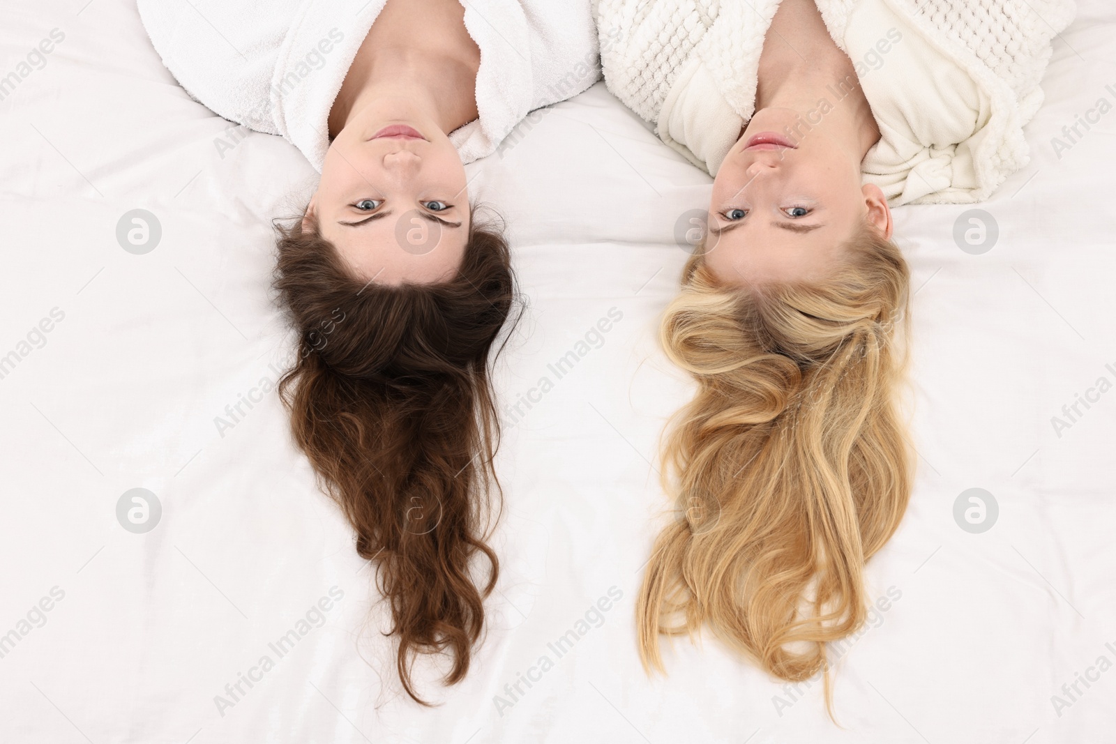 Photo of Spa day. Happy women lying on bed, above view