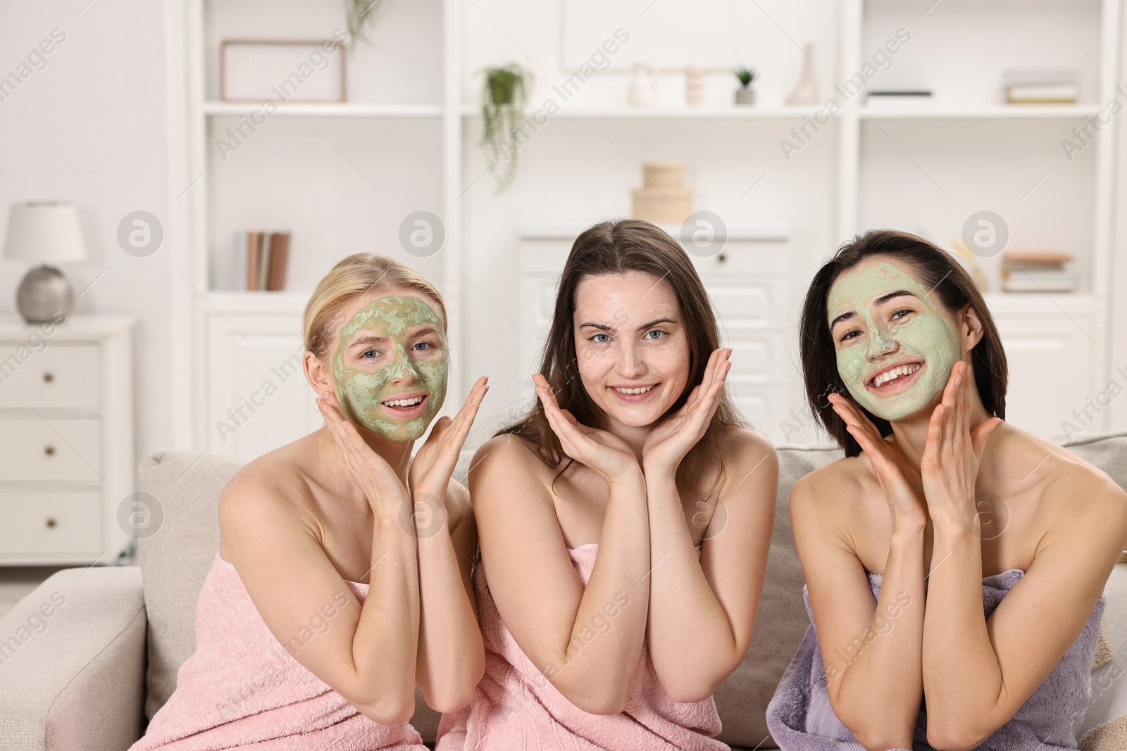 Photo of Spa day. Beautiful women with face masks on sofa indoors