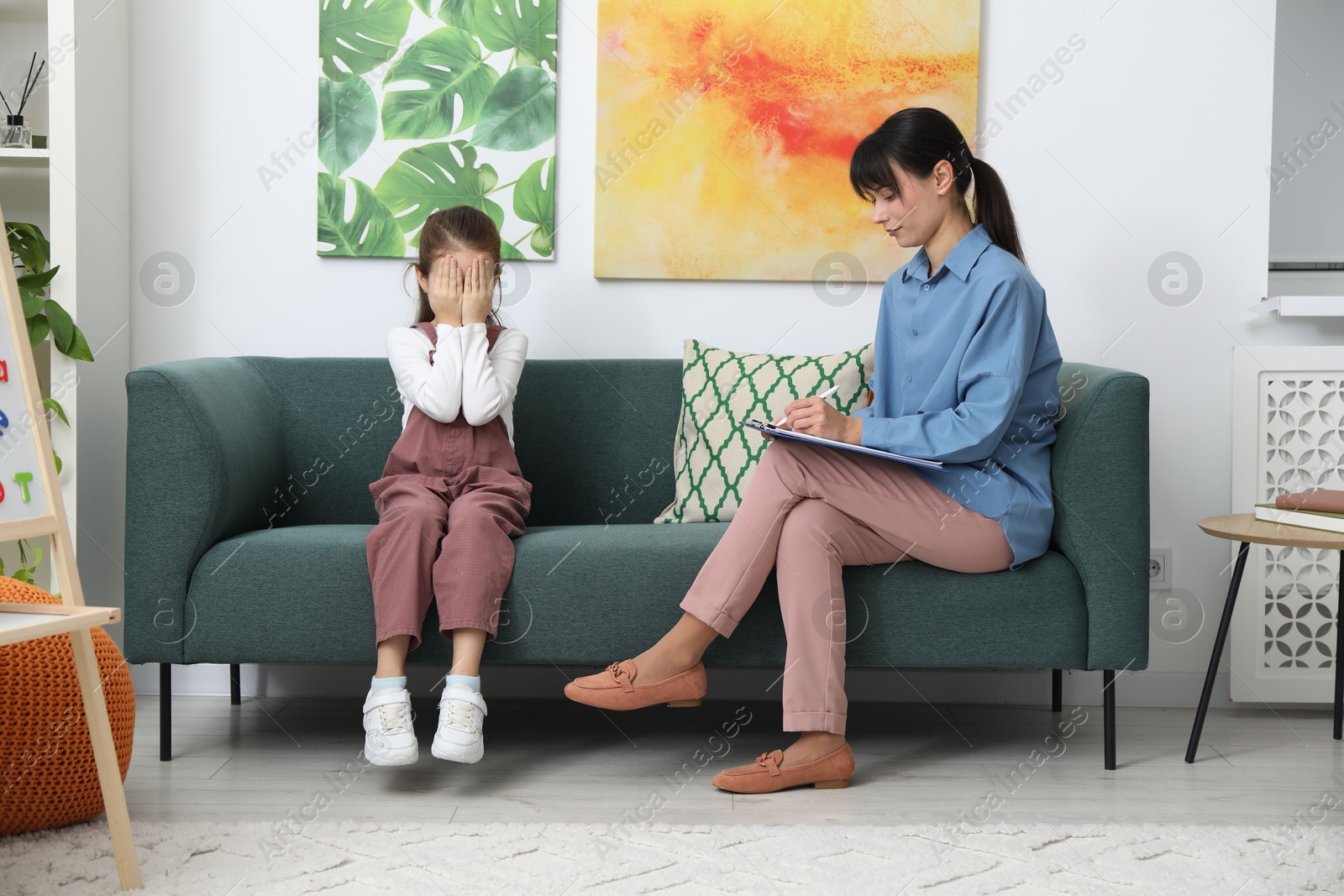 Photo of Upset girl having consultation with psychologist in office